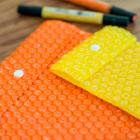 Envelope em plástico bolha laranja e amarelo, personalizável para brindes e press kits
