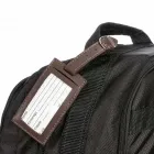 Tag identificador de bagagem de couro sintético.