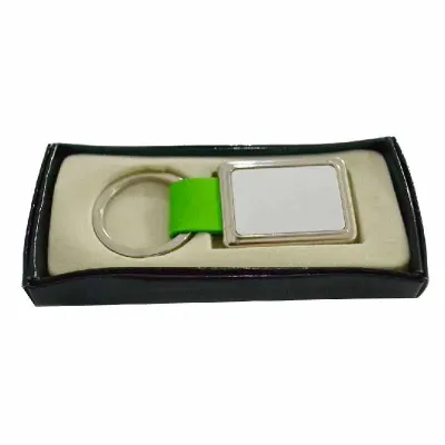 Chaveiro de metal com detalhe verde acondicionado em caixa para presente