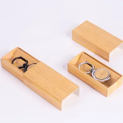 Chaveiro de metal, com detalhe circular de Bambu. Acompanha estojo de papel.