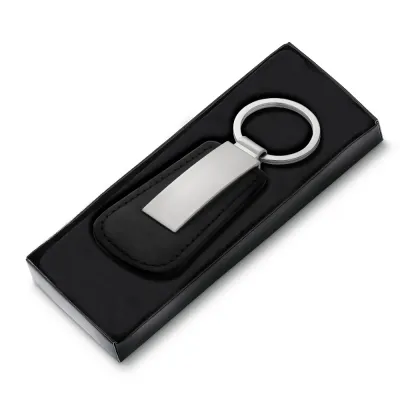 Chaveiro de metal fosco e couro sintético, frente lisa e verso com um parafuso.